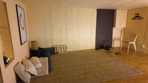 Woven rug and simple furnishings in the softly lit retreat room.